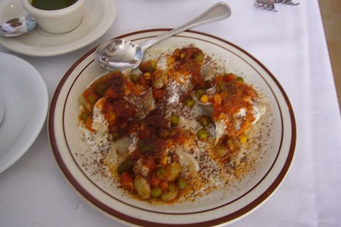 Representative photograph of Afghan Mantu. The photograph includes peas and a red sauce; this recipe uses a yellow split-pea topping.