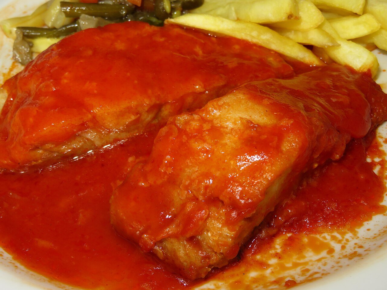 Representative photograph of Bacalao con Tomate. The photograph includes chips not included in this recipe.
