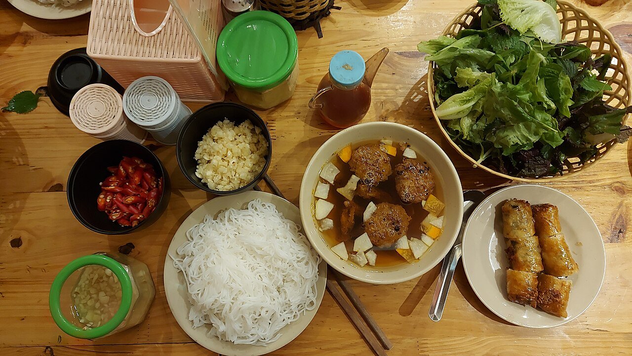 Representative photograph of Bun Cha. The photograph includes spring rolls and extra herbs not included in this recipe.