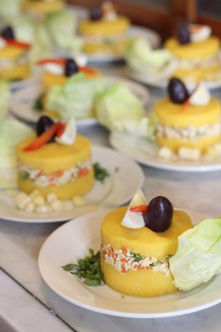 Representative photograph of Causa Limena. The photograph shows individual portions with olives and extra garnish; this recipe sets causa in one dish.