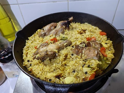 Representative photograph of Chicken Paella. The photograph uses larger bone-in chicken pieces and some different vegetables; this recipe uses cubed thighs.