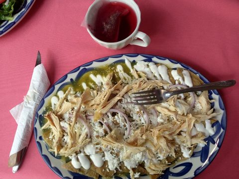 Representative photograph of Chilaquiles Verdes. The photograph includes shredded chicken; this recipe makes meat-free chilaquiles.