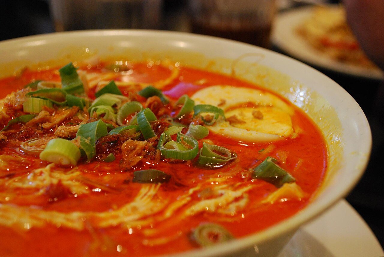 Representative photograph of Curry Laksa. The photograph shows chicken curry noodle soup with egg and other garnishes; this recipe omits the egg topping.