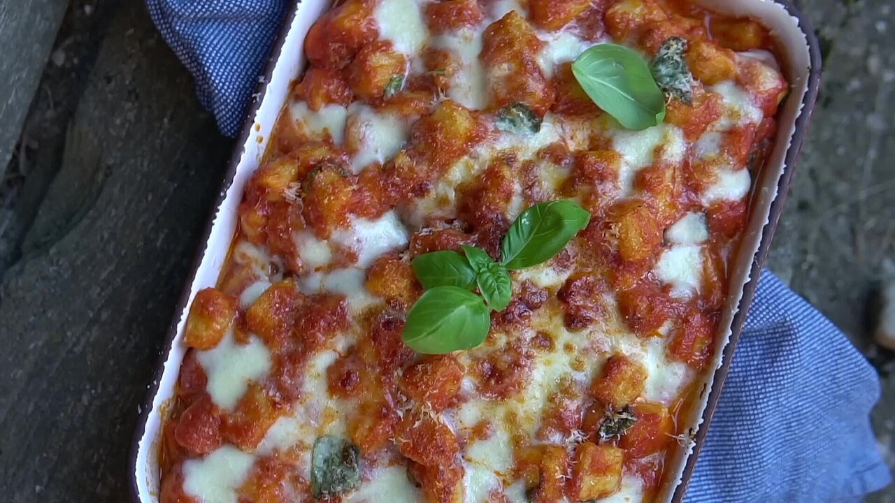 Representative photograph of Gnocchi with Tomato Sauce. The photo shows gnocchi baked with cheese in tomato sauce; this recipe boils gnocchi and serves it in tomato sauce without baking.