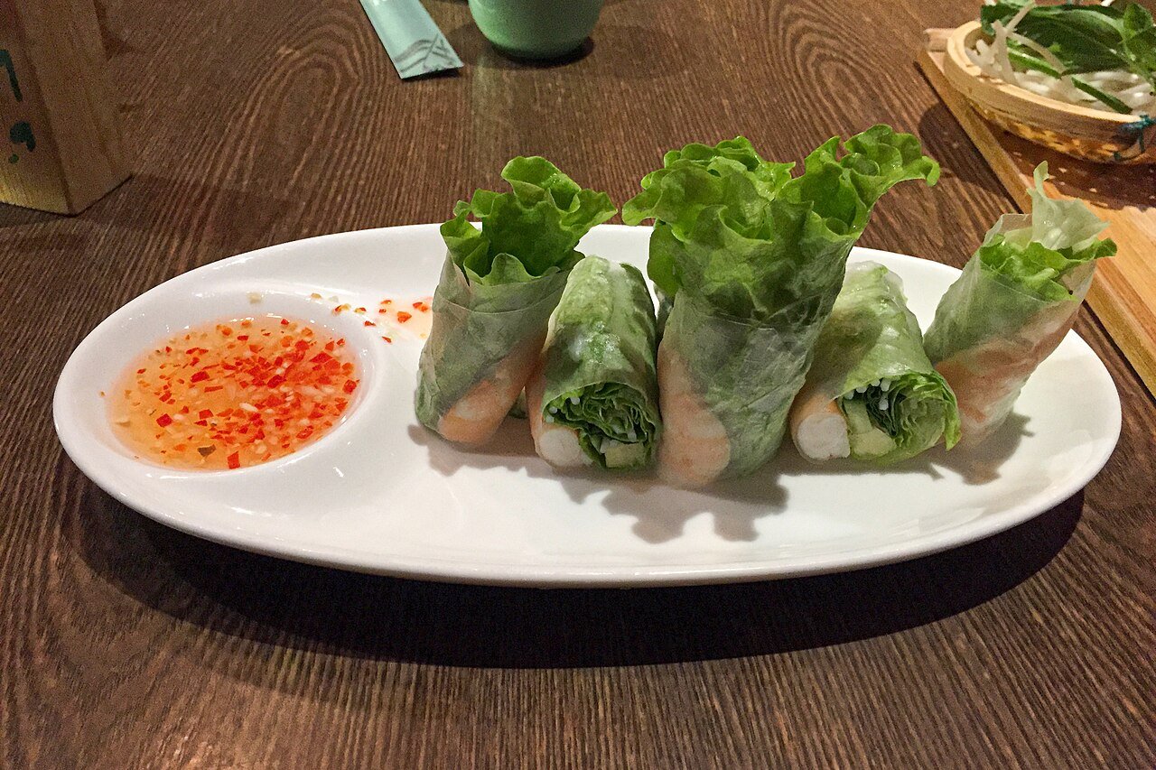 Representative photograph of Goi Cuon. The photograph shows a chili dipping sauce; this recipe uses peanut-hoisin sauce.