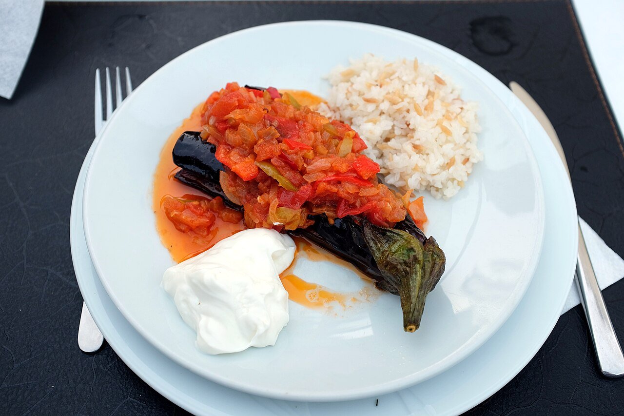 Representative photograph of Imam Bayildi. The photograph includes rice and yogurt not included in this recipe.