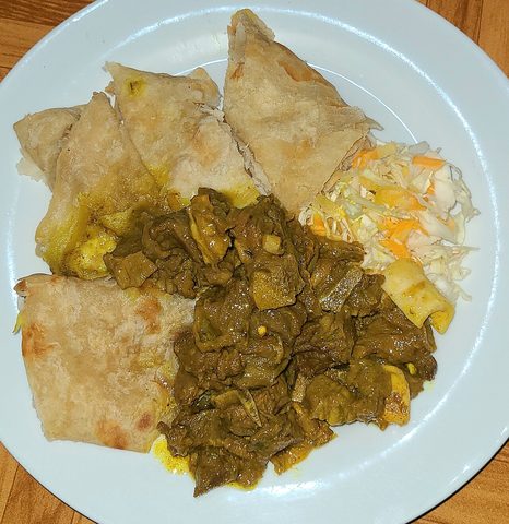 Representative photograph of Jamaican Curry Goat. The photograph includes roti and slaw not included in this recipe.