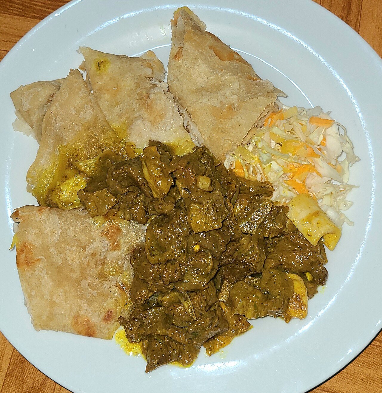 Representative photograph of Jamaican Curry Goat. The photograph includes roti and slaw not included in this recipe.