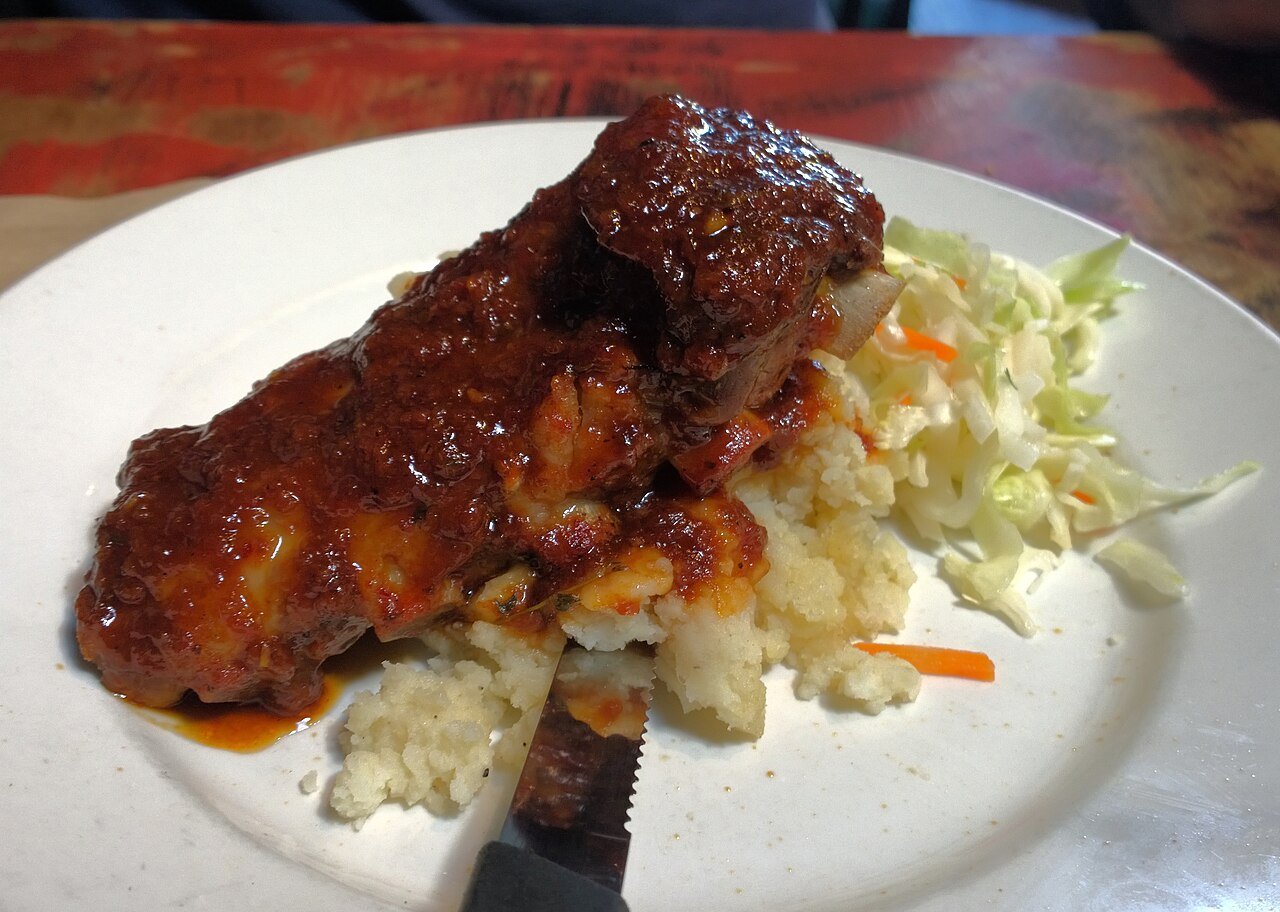 Representative photograph of Jamaican Jerk Chicken. The photograph includes rice and slaw not included in this recipe.