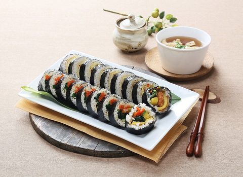 Representative photograph of Kimbap. The photographed rolls and side dishes include fillings that can differ from the vegetable-and-egg filling in this recipe.