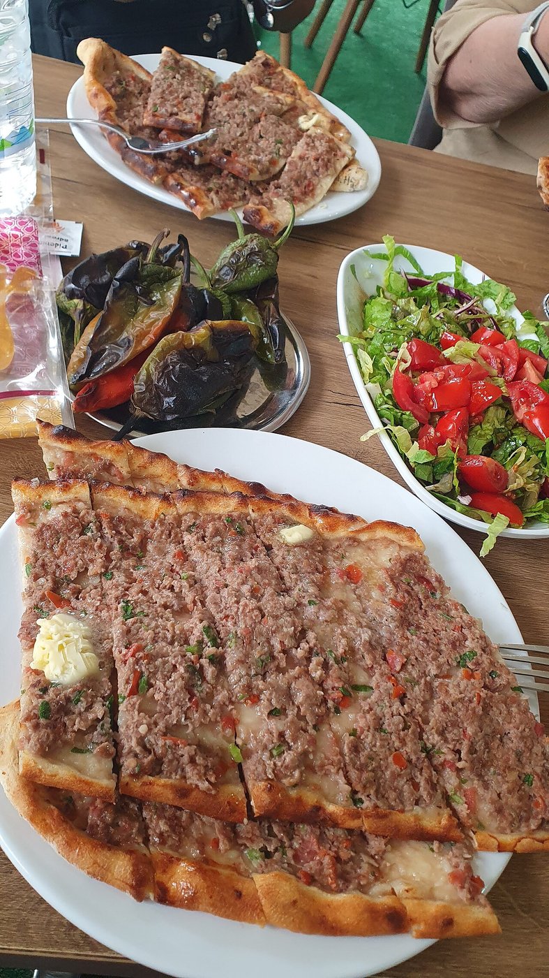 Representative photograph of Kiymali Pide. The photograph includes other dishes in the background; this recipe makes only the minced-meat pide.