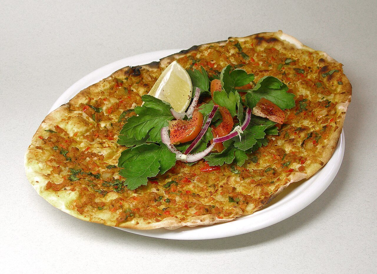 Representative photograph of Lahmacun. The photograph includes lemon and salad garnish not included in this recipe.