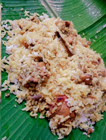 Chicken biryani served on a green banana leaf