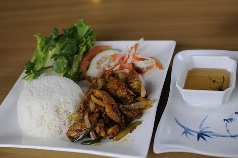 Representative photograph of Lemongrass Chicken. Rice and salad are shown as side dishes.