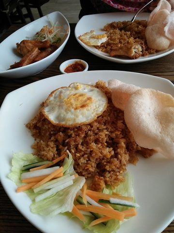 Representative photograph of Nasi Goreng. The photograph includes crackers and salad accompaniments not included in this recipe.