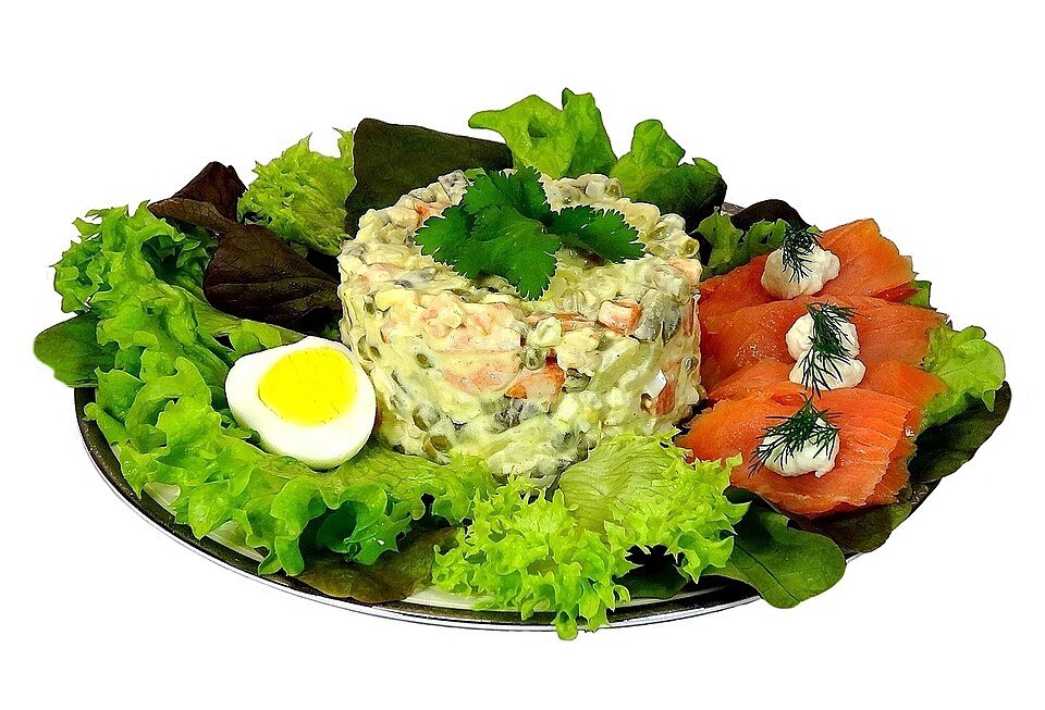 Representative photograph of Olivier Salad. The photograph includes salmon and lettuce as accompaniments.