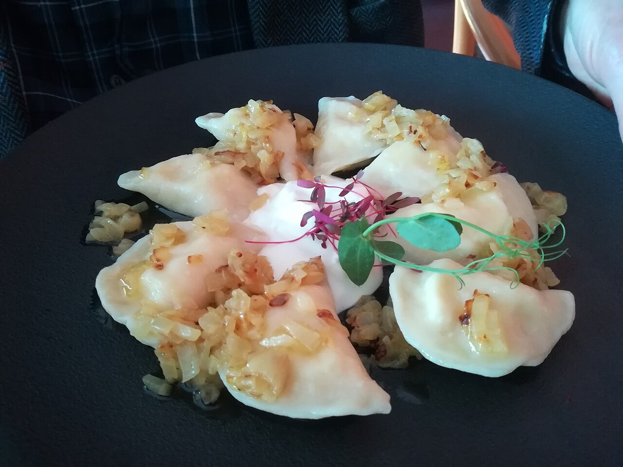 Representative photograph of Pierogi Ruskie. The photograph includes onion and other garnish on top; this recipe serves the dumplings with butter.