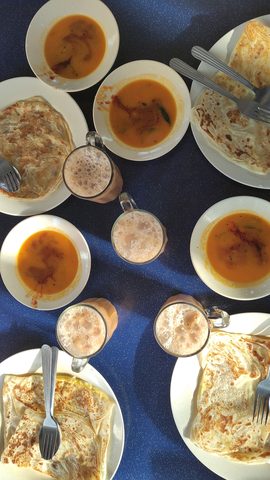 Representative photograph of Roti Canai. The photograph shows a breakfast spread with curry and drinks; this recipe makes the roti only.