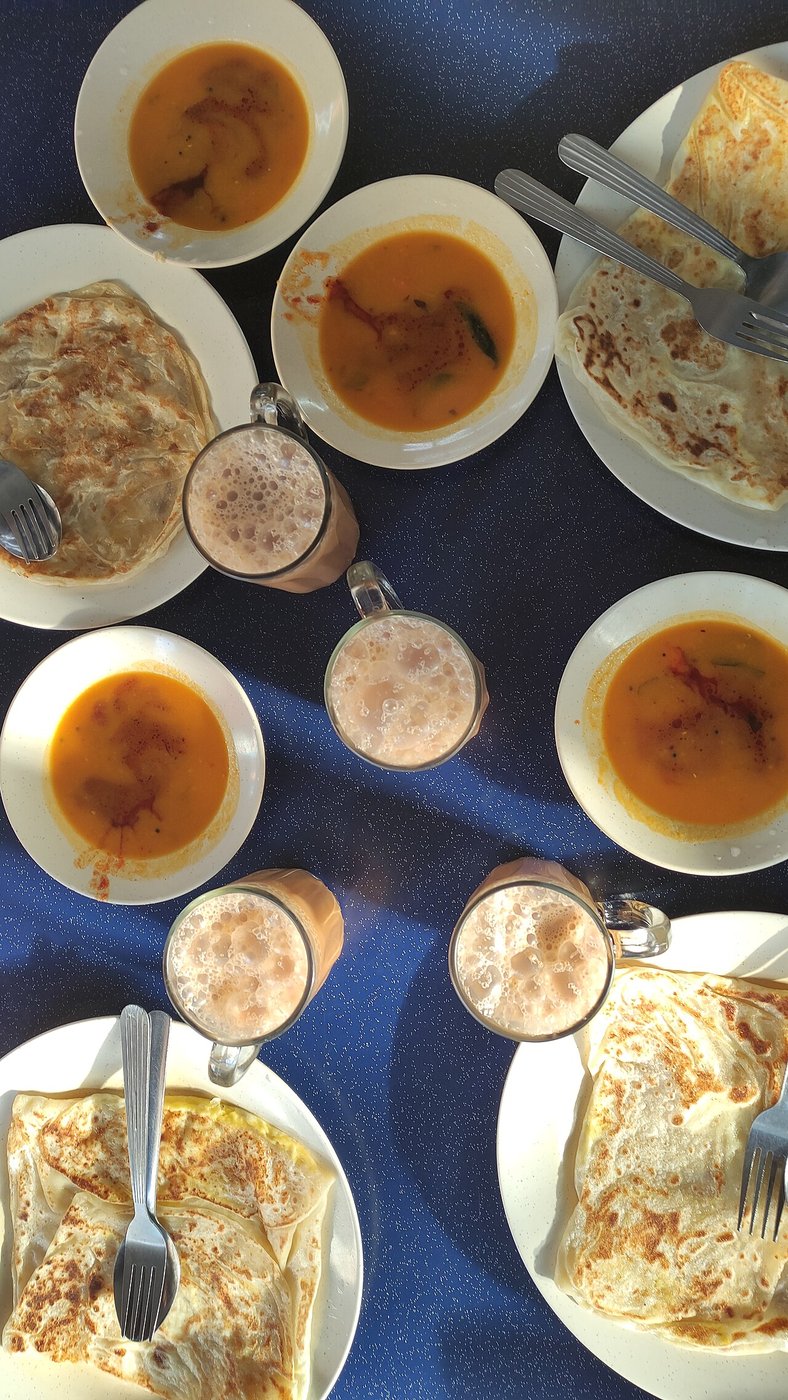 Representative photograph of Roti Canai. The photograph shows a breakfast spread with curry and drinks; this recipe makes the roti only.