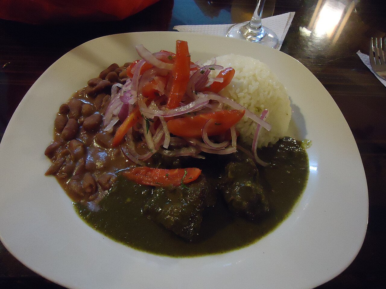 Representative photograph of Seco de Res. The photograph includes rice, beans and onion garnish not included in this recipe.