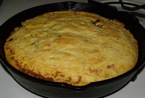 Representative photograph of Skillet Cornbread. The photograph includes visible green additions not included in this plain cornbread recipe.
