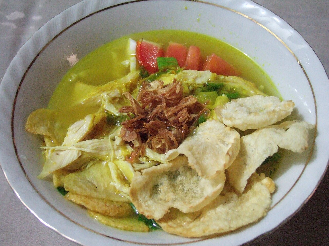 Representative photograph of Soto Ayam. The photograph includes crackers and fried shallots not included in this recipe.