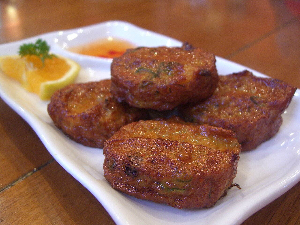 Representative photograph of Thai Fish Cakes. The photo includes dipping sauce and garnish not included in this recipe.