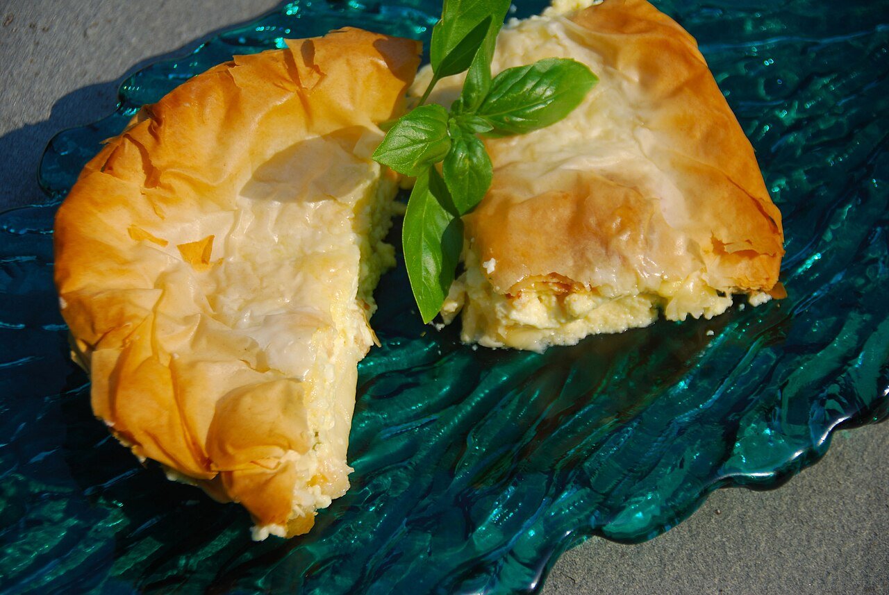 Representative photograph of Tiropita. The photograph shows a folded cheese pie; this recipe makes a layered tray pie.